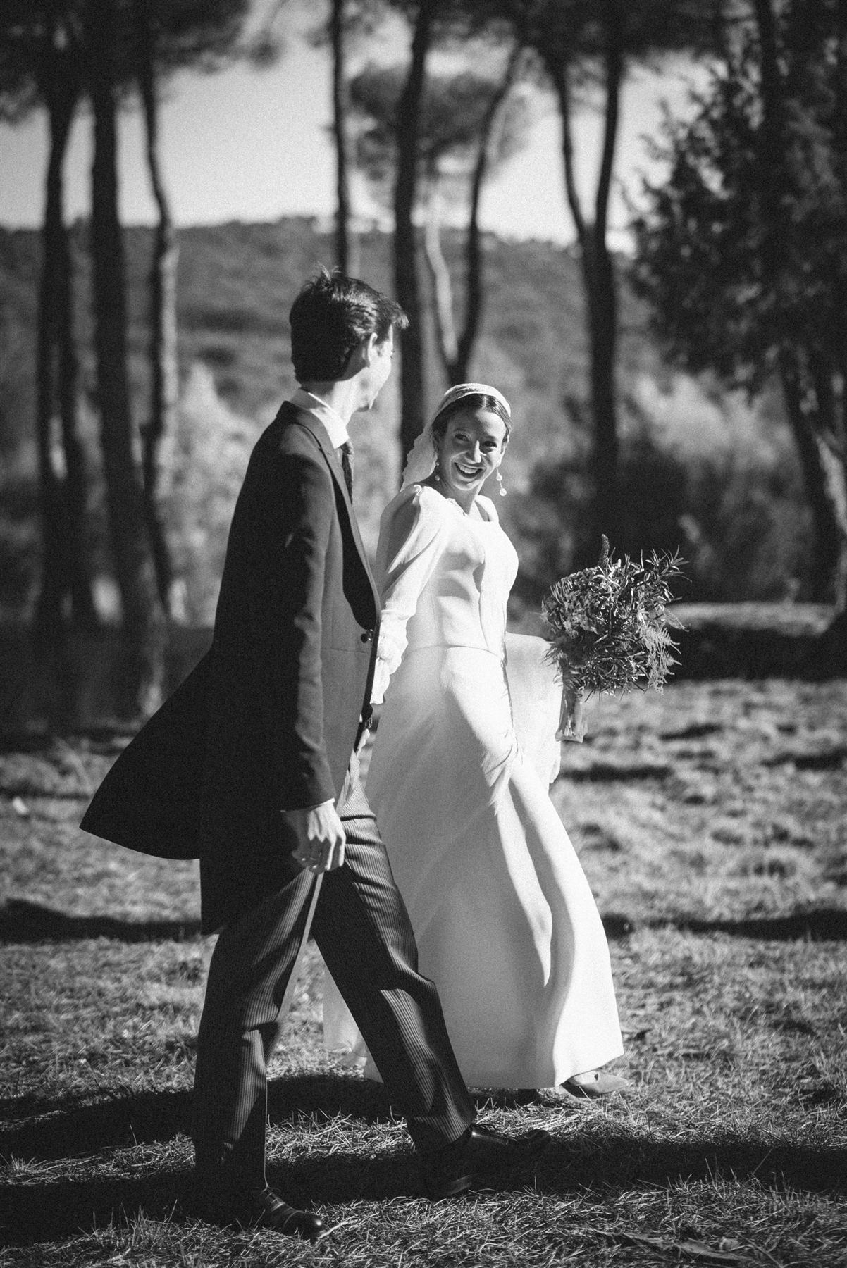 Novia riendo junto al novio, retrato en blanco y negro entre pinos